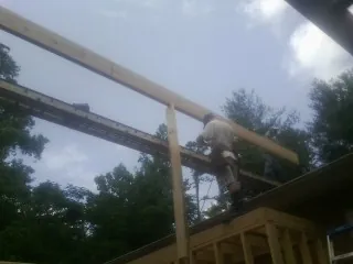Carpenter setting a ridge beam over a new addition frame — Ice Dam Removal by Roofing Brothers in Dearborn Heights