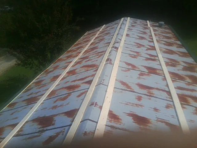 Rusted metal roof panels with new wood purlins before replacement — Storm Damage Roof Repair in Dearborn Heights by Roofing Brothers
