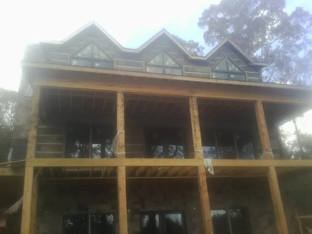 Dormers and porch framing on a large log home under construction — Roof Coating work by our crew in Dearborn Heights