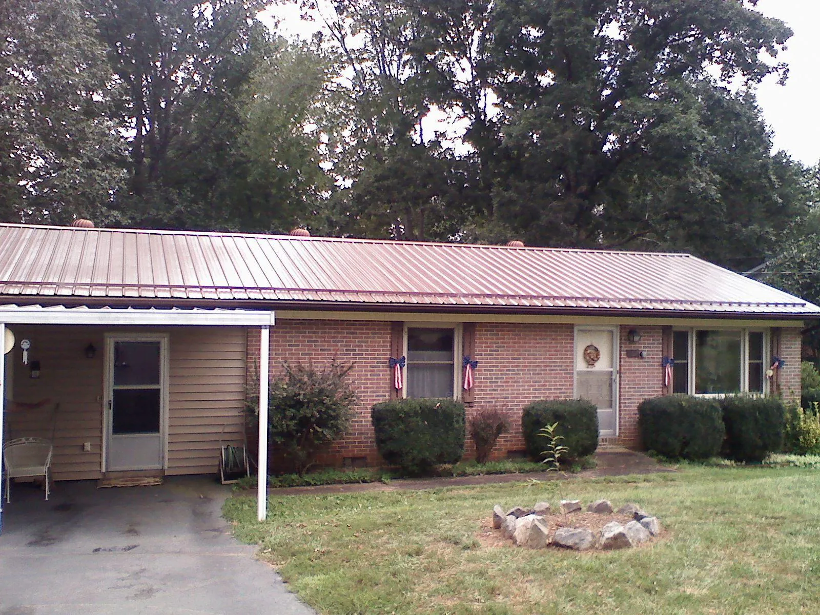 Bronze metal roof and carport on a brick ranch home — Roof Repair work by our crew in Dearborn Heights
