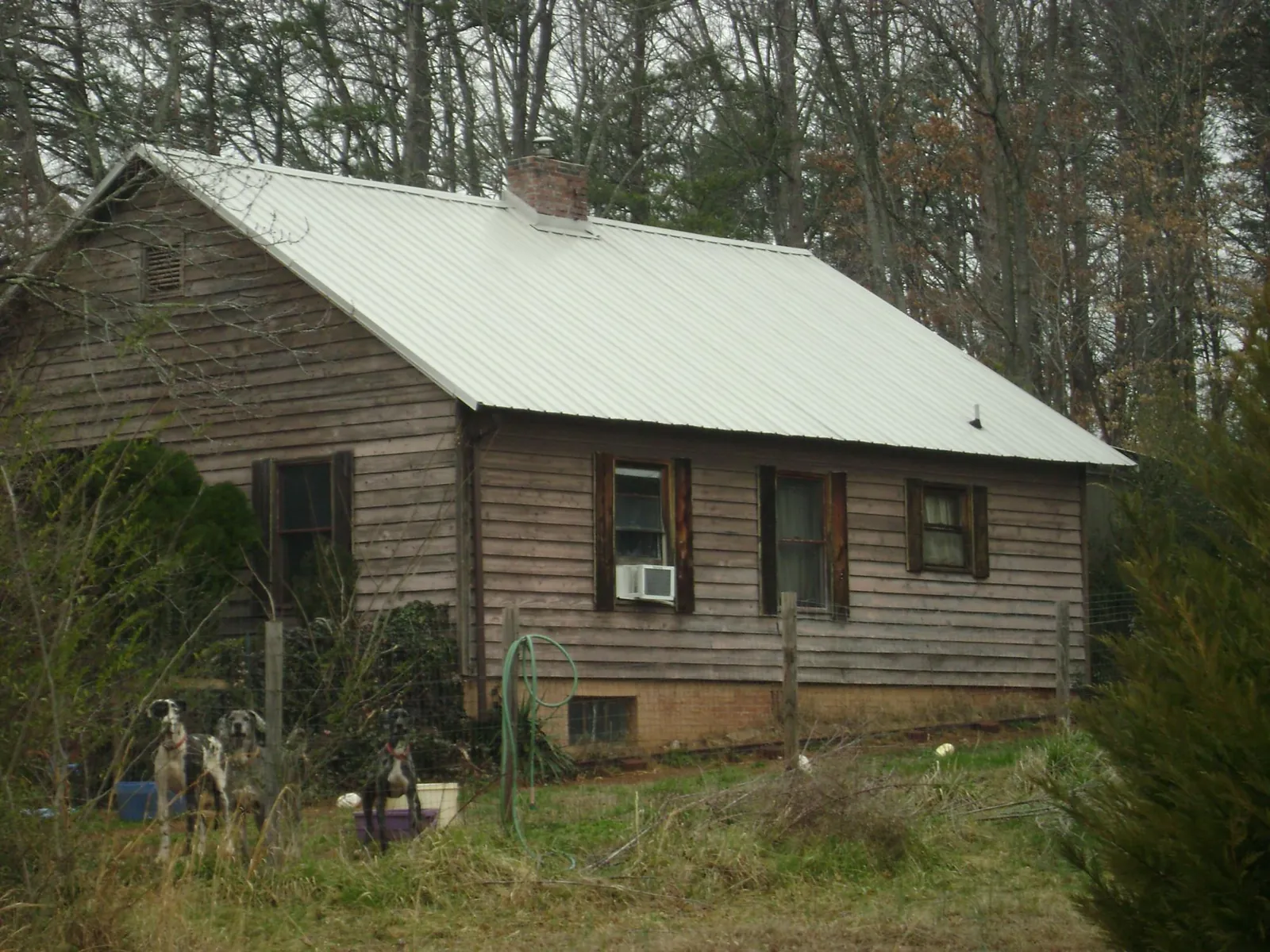 White metal roof on an old wood sided farmhouse, from a Metal Roof Installation job in Dearborn Heights